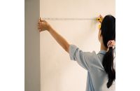 image of someone measuring a wall