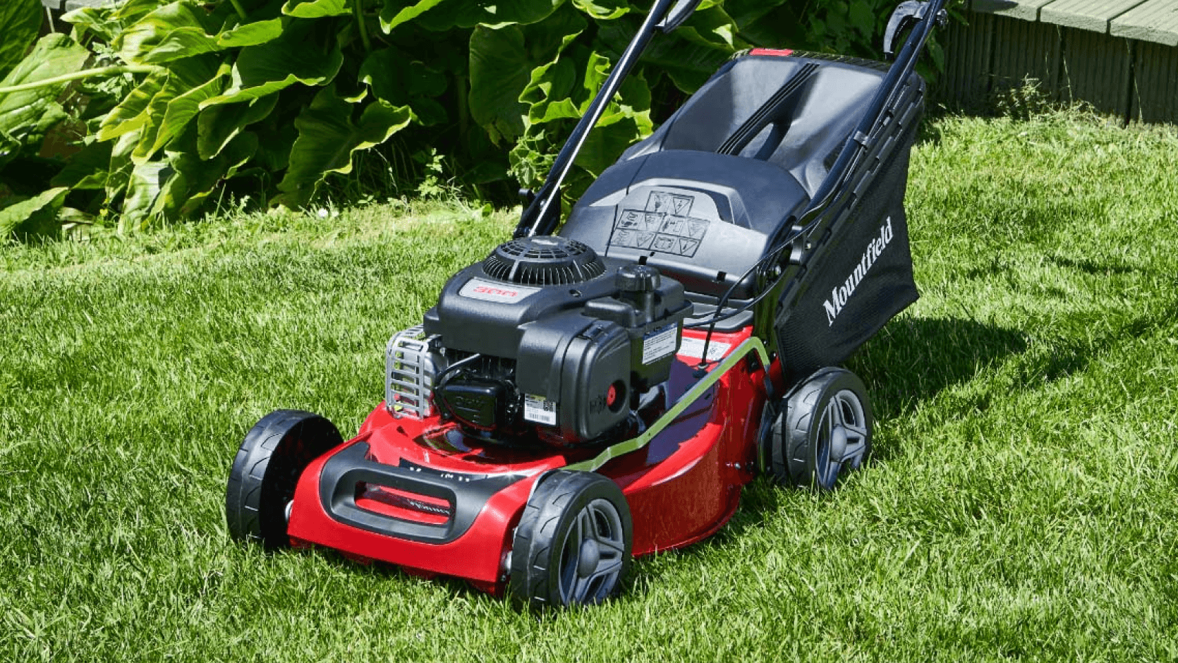 A red lawnmower sitting on short grass